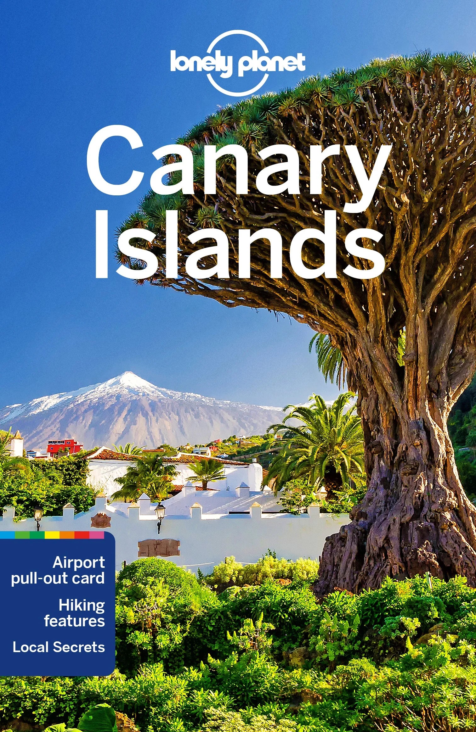 Forsidebilde av reiseguideboken "Canary Islands" av Lonely Planet. Bildet viser et ikonisk drageblodstre i forgrunnen med snødekte fjell i bakgrunnen, sannsynligvis El Teide på Tenerife. Forsiden nevner "Airport pull-out card," "Hiking features," og "Local Secrets."