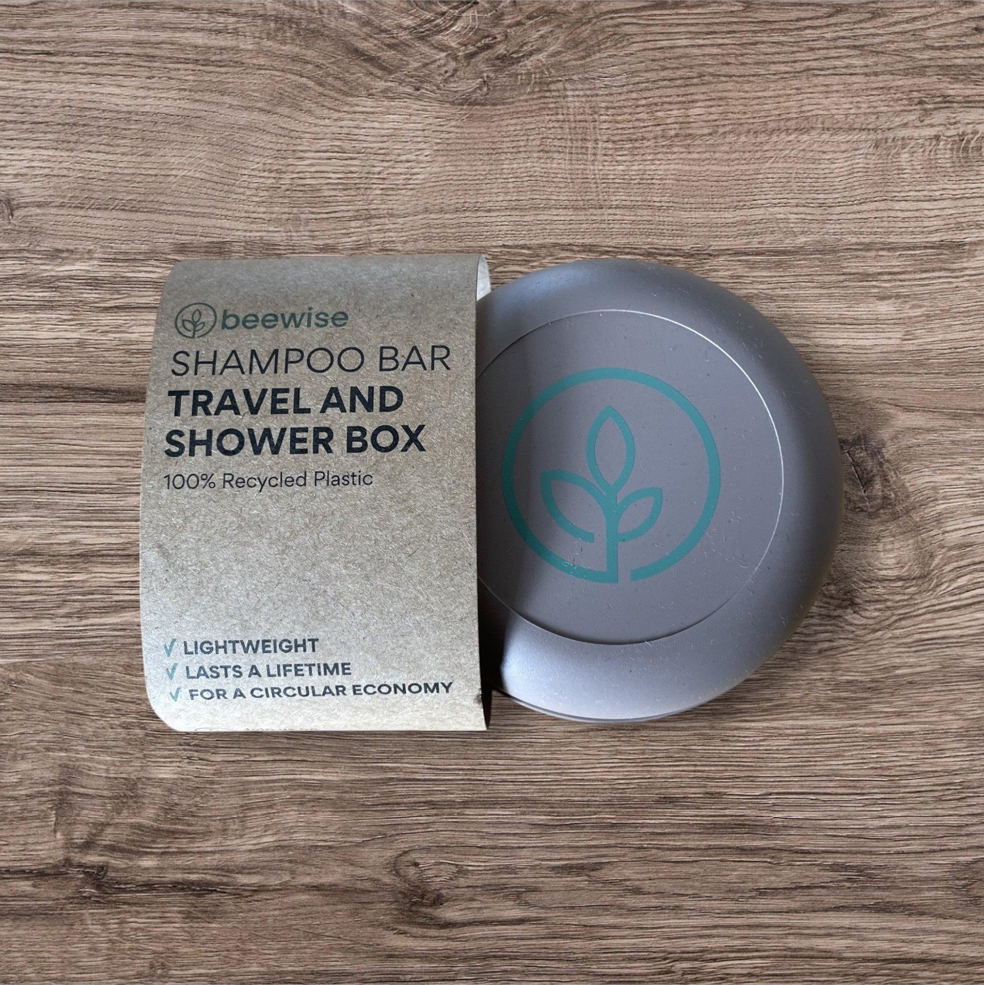 Beewise Shampoo Bar Travel and Shower Box med emballasje: Dette bildet viser sjampoboksen med originalemballasjen som fremhever boksen laget av 100% resirkulert plast. På emballasjen står det “Lettvekt, varer livet ut, for en sirkulær økonomi.” En flott løsning for miljøbevisste reisende.